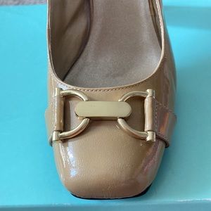 Closed toe sling-back shoes with gold toned hardware.